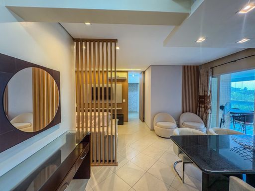 Sala com espelho e painel vazado

Aparador de madeira com espelho circular integrado à área de estar.

Perspectiva focada no hall de entrada e na circulação interna da residência. Um elegante aparador de madeira escura com tampo de vidro acompanha um grande espelho redondo fixado na parede, ampliando visualmente o espaço. A divisória ripada vertical de madeira atua como cenário de fundo, permitindo visualizar a sala de TV e o corredor com portas. À direita, a mesa de jantar com tampo preto e cadeiras estofadas completam a composição arquitetônica, ressaltada pelos pontos de luz embutidos no gesso que criam um clima residencial requintado e limpo.