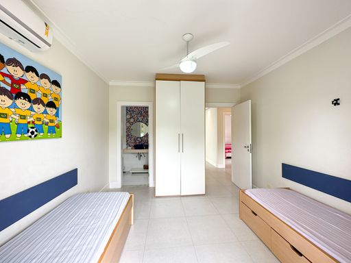 Visão geral de quarto infantil planejado

Quarto de solteiro com armário centralizado, duas camas e vista para o banheiro.

Esta imagem revela a amplitude do quarto infantil, mostrando o armário planejado branco centralizado entre os acessos do cômodo. As duas camas com painéis azuis estão dispostas nas laterais sobre o piso cerâmico claro e plano. Ao fundo, a porta aberta revela o banheiro social decorado com a cuba vermelha, evidenciando a distribuição integrada e prática da planta do imóvel. O teto clean com ventilador de alta vazão e spots embutidos reforça a iluminação eficiente e a sensação de organização do espaço.