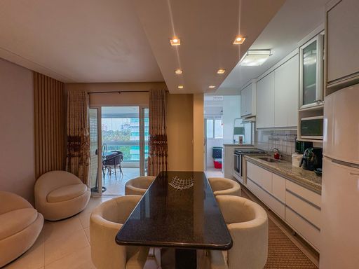 Sala de jantar integrada à cozinha

Mesa de jantar preta com cadeiras estofadas integrada com cozinha americana branca.

Uma sofisticada sala de jantar totalmente integrada à cozinha sob um conceito aberto. O destaque é a mesa retangular com tampo de granito escuro, cercada por cadeiras estofadas em tom off-white com design curvo. À direita, a cozinha planejada exibe armários aéreos e balcões brancos lineares com puxadores de perfil metálico. O teto rebaixado em gesso apresenta spots com iluminação amarelada e acolhedora, enquanto o piso de porcelanato claro polido conduz o olhar em direção à varanda ensolarada ao fundo, criando uma atmosfera residencial integrada, fluida e elegante.
