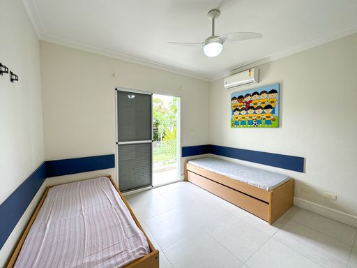 Quarto infantil com bicama embutida

Quarto com duas camas de solteiro de madeira, painel azul e quadro colorido.

Este quarto de solteiro foi projetado com foco no aproveitamento de espaço e conforto. Conta com duas camas com estrutura em madeira clara, sendo uma delas uma bicama com gavetões inferiores para armazenamento. Painéis horizontais estofados em azul escuro atuam como cabeceira de proteção nas paredes brancas. Um quadro artístico colorido com desenhos infantis alegra o espaço acima de uma das camas. Uma grande porta de correr com tela mosquiteira dá acesso direto ao jardim externo, oferecendo ventilação abundante e um clima térmico fresco e agradável.