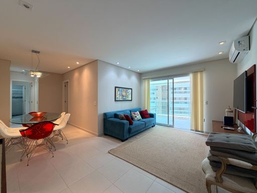 Sala de estar com sofá azul
Sala de estar integrada com sofá azul, tapete sisal e porta de correr de vidro.
Este elegante living planejado destaca-se pela sofisticação do sofá de três lugares em tecido azul turquesa com almofadas decorativas. O ambiente conta com um grande tapete de sisal bege sobre o piso de porcelanato claro, delimitando a área de TV. Uma grande porta de correr de vidro com cortinas claras traz iluminação natural abundante da sacada, criando uma sensação de amplitude, aconchego térmico e sofisticação contemporânea na área social.