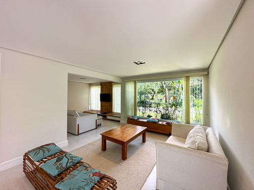 Sala de estar com vista externa

Sala de estar com sofás claros, mesa de centro de madeira e grande janela para o jardim.

Uma ampla sala de estar interna que prioriza a integração com a natureza externa por meio de uma imensa parede de vidro que emoldura o jardim verde. O mobiliário é composto por um aconchegante sofá de tecido branco, poltronas de fibra natural com almofadas estampadas e uma robusta mesa de centro retangular em madeira maciça. O teto rebaixado em gesso possui spots de iluminação embutidos e discretos. O piso em porcelanato claro e os tons neutros dos estofados geram um equilíbrio térmico visual refrescante e muito elegante.