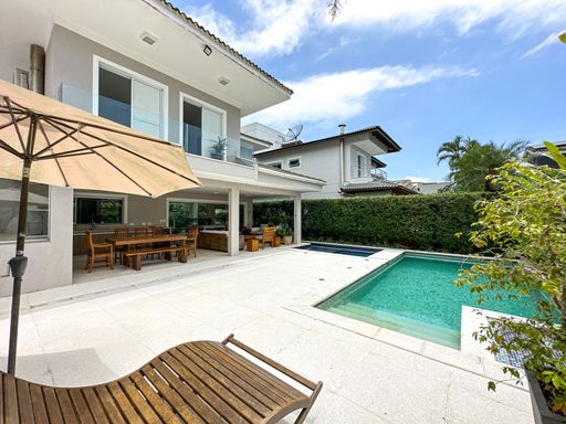 Área externa com piscina privativa

Piscina de alvenaria em deck de pedra clara ao lado de casa moderna.

A área de lazer externa desta residência de alto padrão oferece um amplo espaço ensolarado para convivência. A piscina retangular é revestida com pastilhas em tons de azul e verde-água, emoldurada por um deck de pedra clara antiderrapante e antitérmica. Uma espreguiçadeira de madeira anatômica está posicionada em primeiro plano para banhos de sol. Ao fundo, a fachada da casa exibe linhas contemporâneas em tons de cinza, com uma grande varanda coberta equipada com ombrelone e mesa de jantar externa, transmitindo luxo e sofisticação.