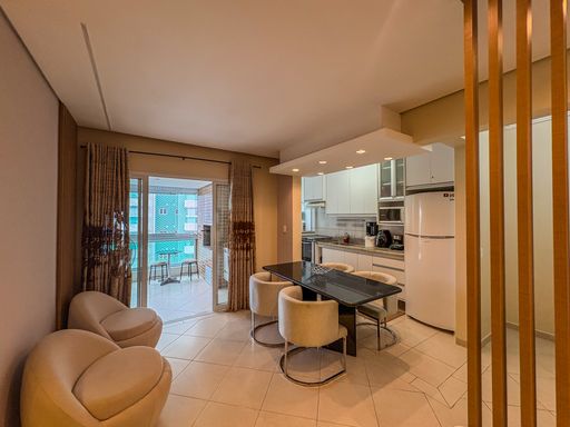 Sala de jantar e varanda integradas

Mesa de jantar integrada com cozinha americana e vista para varanda.

Visão ampla que capta a integração completa dos ambientes sociais do apartamento. A área de jantar exibe uma mesa retangular preta com cadeiras estofadas elegantes, posicionada estrategicamente entre a cozinha de móveis planejados brancos e a sala de estar. O piso de porcelanato claro polido estende-se uniformemente por todo o espaço, refletindo a abundante iluminação natural que entra pela grande porta de correr de vidro. A abertura revela uma varanda com cortinas fluidas e mureta de vidro, criando uma atmosfera residencial arejada, fresca e sofisticada.