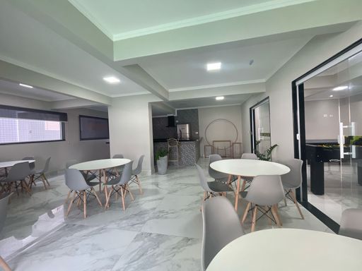 salão de festas semi integrado ao salão de jogos com porta de correr de vidro