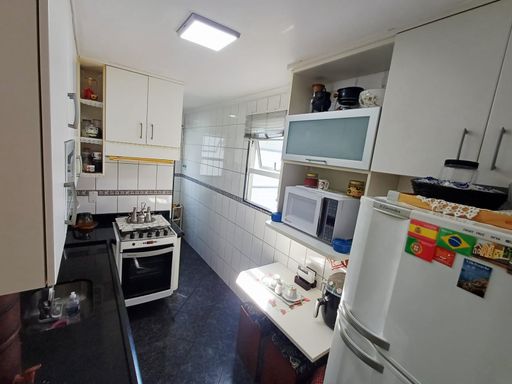 cozinha bem arejada com pia ampla em granito preta e armários planejados