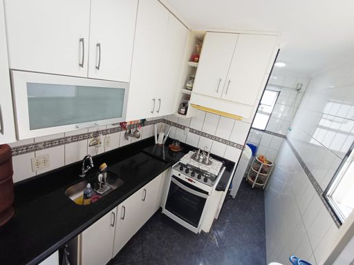 cozinha bem arejada com pia ampla em granito preta e armários planejados