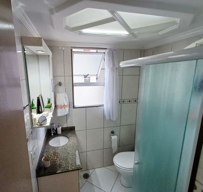 banheiro com box blindex e armário planejado bem arejado