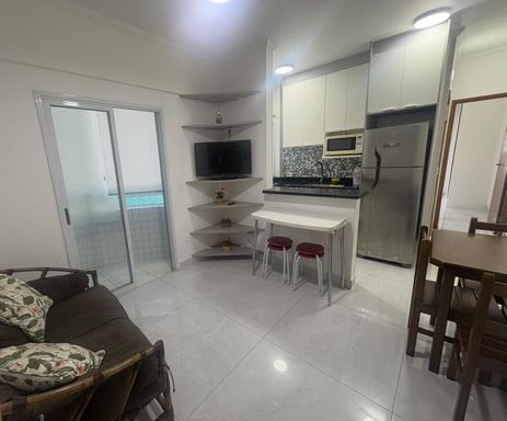 Sala semi integrada a cozinha com armários planejados e acesso a sacada envidraçada e com cortina blackout