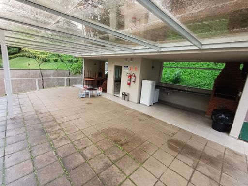 espaço gourmet arborizado com churrasqueira a carvão e forno a lenha