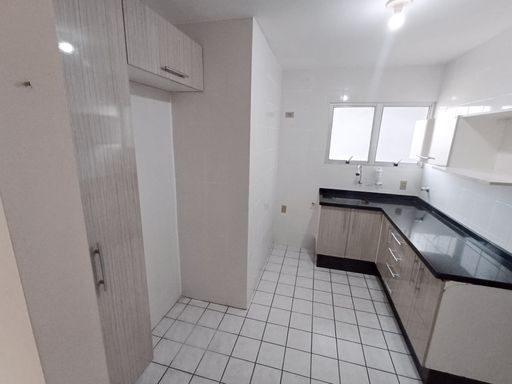 cozinha bem arejada e iluminada com armários planejados e ampla pia em granito preta