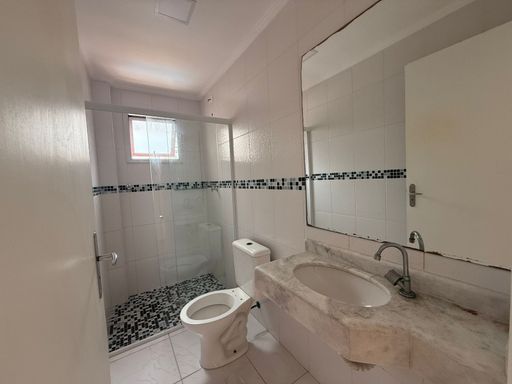banheiro da suíte com box de vidro bem arejado
