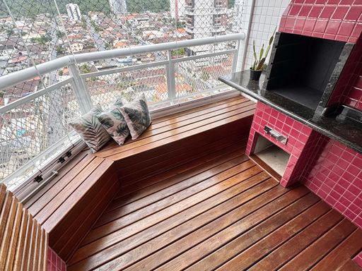 Varanda gourmet em formato de deck com churrasqueira a carvão e vista livre