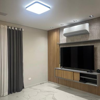 sala em porcelanato com teto rebaixado e sistema de iluminação em LED com total requinte.