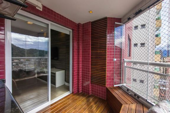 Varanda gourmet em formato de deck com churrasqueira a carvão e vista livre