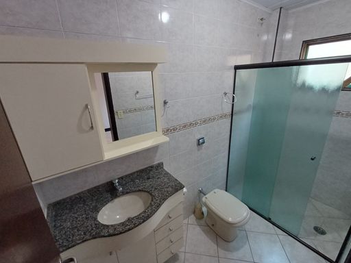 banheiro da suíte com armário planejado e box de vidro