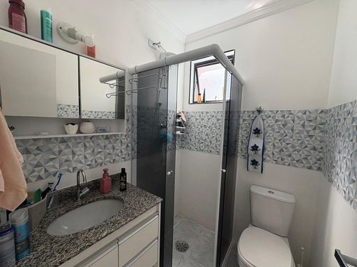 banheiro em total requinte com armário planejado e box de vidro bem arejado