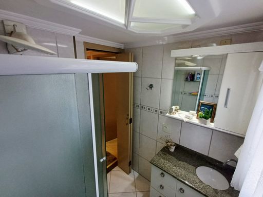 banheiro com box blindex e armário planejado bem arejado