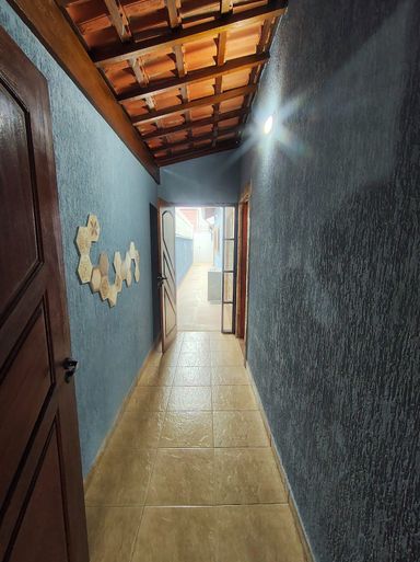corredor com acesso ao quintal e a churrasqueira a carvão