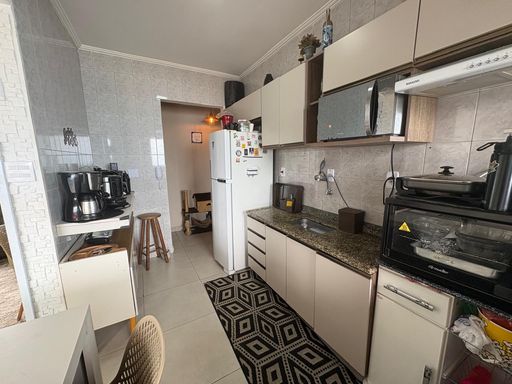 cozinha com armários planejados e acesso a entrada principal