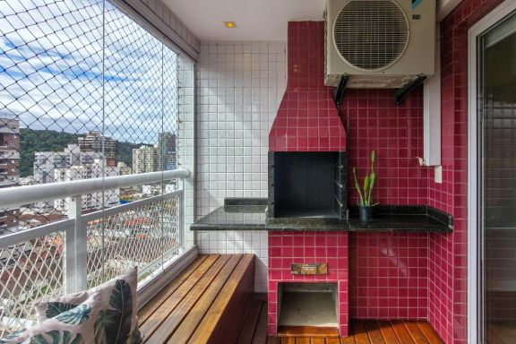 Varanda gourmet em formato de deck com churrasqueira a carvão e vista livre