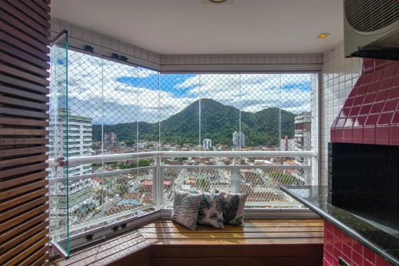 Varanda gourmet em formato de deck com churrasqueira a carvão e vista livre