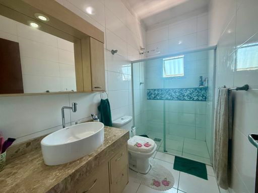 banheiro com armário planejado e box de vidro bem arejado