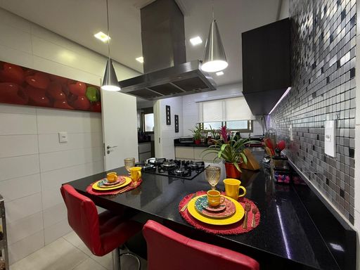 cozinha arejada ultra moderna com armários planejados e balcão amplo em granito preto