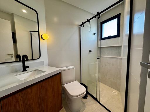 banheiro da suíte bem arejado com box blindex e nicho