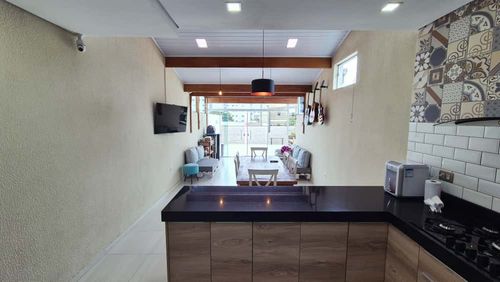 espaço gourmet no piso superior em total requinte, com armários planejados e ampla pia em granito preta com cooktop