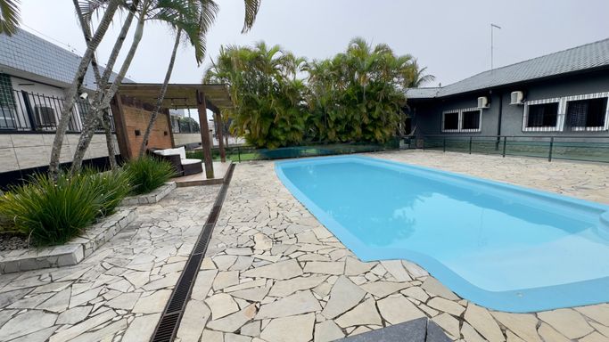 área de piscina com lounge e pergolado