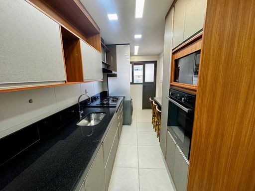 cozinha semi integrada a área de serviço com acesso a área técnica