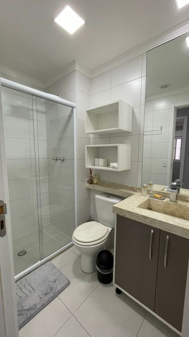 banheiro social com box de vidro e armário planejado