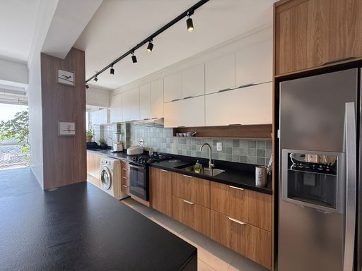 cozinha padrão americana com móveis planejados de primeiríssima qualidade, semi integrada a área de serviço e a varanda gourmet
