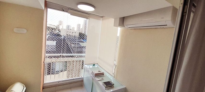 varanda envidraçada transformada em home office, com moveis planejados , cortina blackout e ar condicionado