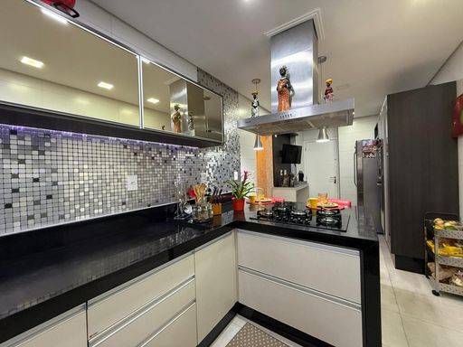 cozinha arejada ultra moderna com armários planejados e balcão amplo em granito preto