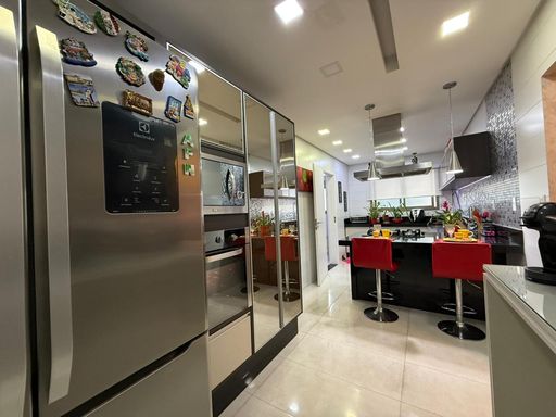 cozinha arejada ultra moderna com armários planejados e balcão amplo em granito preto