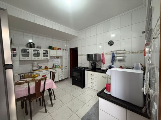 cozinha bem arejada com móveis planejados e ampla pia em granito preta