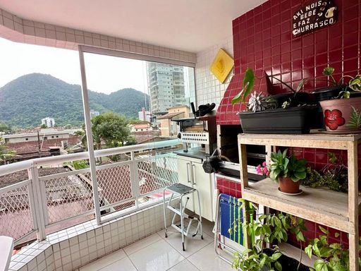 ampla varanda gourmet envidraçada com churrasqueira a carvão