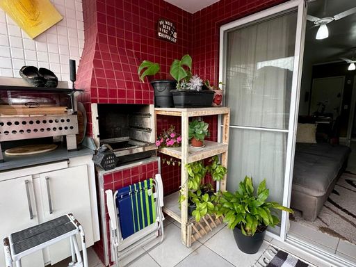 ampla varanda gourmet envidraçada com churrasqueira a carvão
