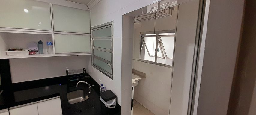 cozinha semi integrada a área de serviço bem arejada com armários planejado