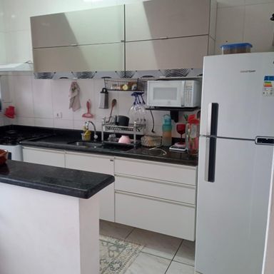 cozinha com armários planejados, ampla pia e balcão em granito preto