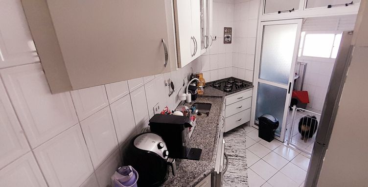 cozinha bem arejada e iluminada com armários planejados, com acesso a área de serviço com porta de vidro