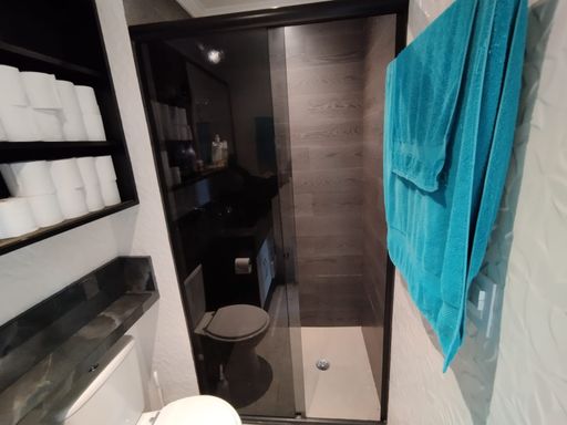 banheiro social ultra moderno com armário planejado e box de vidro fumê
