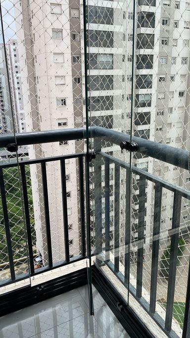 ampla varanda gourmet envidraçada com cortina blackout e vista privilegiada para piscina, andar alto.