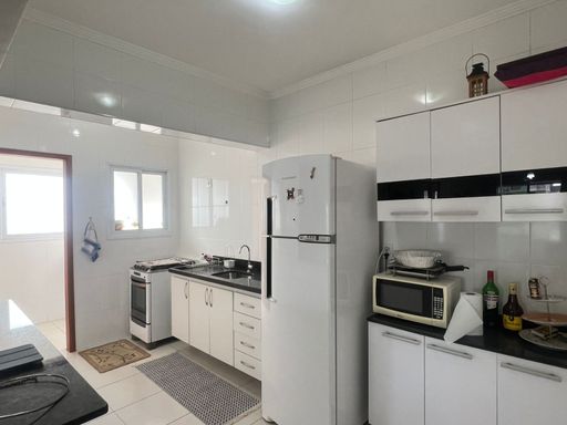 ampla cozinha com acesso a área de serviço bem arejada