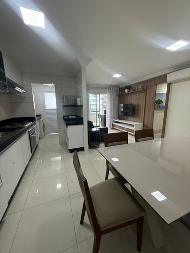 ampla sala 2 ambientes semi integrada a cozinha com armários planejados e a área de serviço bem arejada