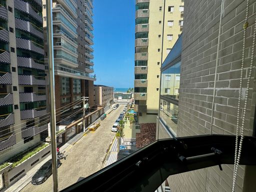 ampla varanda gourmet envidraçada com vista mar privilegiada, churrasqueira a carvão e cortina blackout