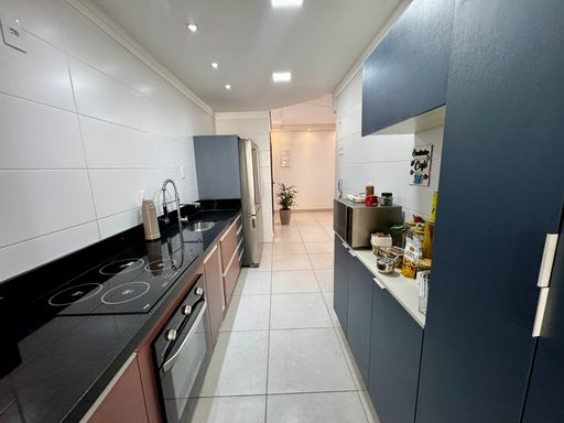 cozinha com móveis planejados semi integrada a área de serviço