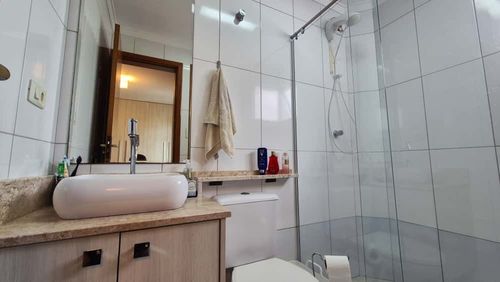 banheiro da suíte bem arejado com armário planejado e box de vidro